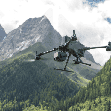 Drone volant devant montagnes verdoyantes.