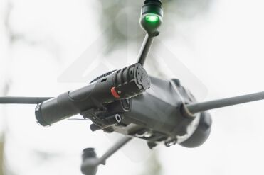 Drone volant avec lumière LED verte allumée.