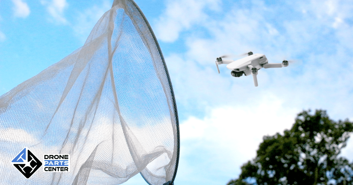Een drone vliegt boven een net in een open luchtomgeving met blauwe lucht en wolken.
