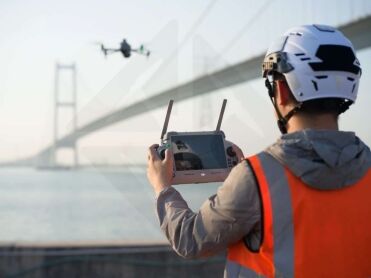 Opérateur pilotant le DJI Matrice 4E à la radiocommande lors d'une inspection de pont.