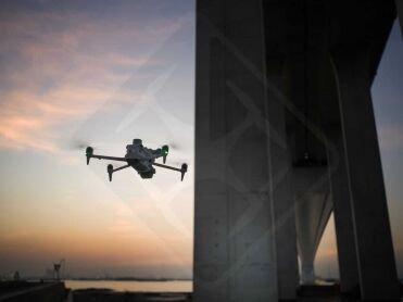 DJI Matrice 4E équipé d'un projecteur lors d'une inspection de pont de nuit.