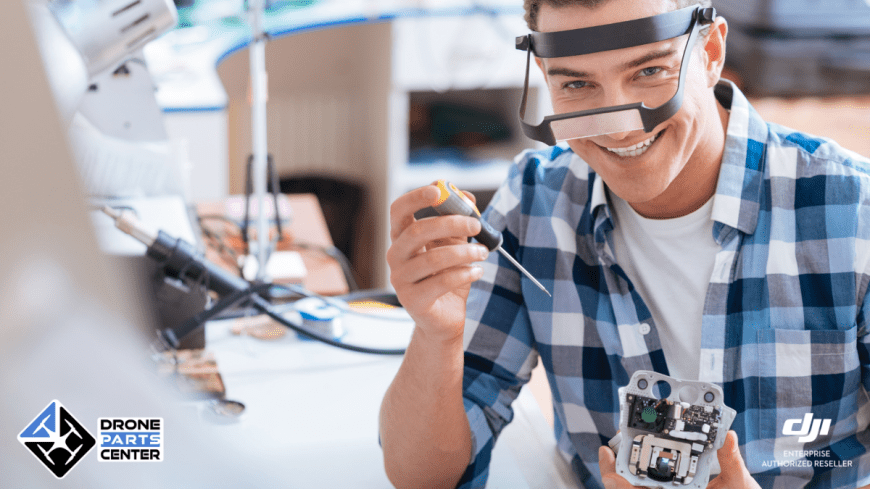 Man die een drone repareert in een werkplaats.