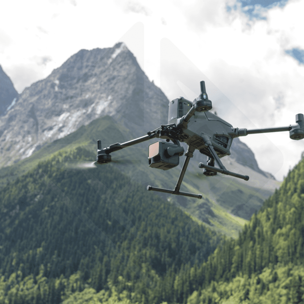 Drohne fliegt vor grünen Bergen.